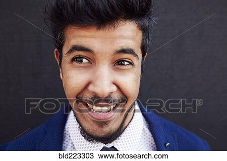 Stock Image - Smiling Middle Eastern man wearing jacket and tie. Fotosearch