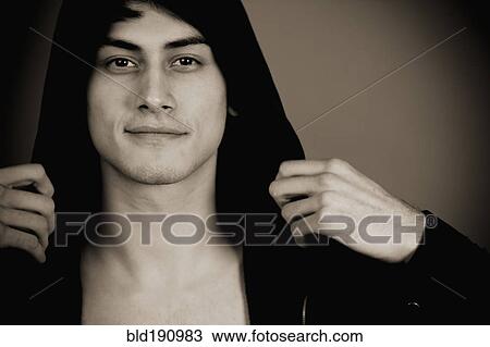 Stock Image - Smiling mixed race man in hooded jacket. Fotosearch