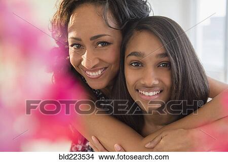 Picture - Smiling mother and daughter hugging. Fotosearch