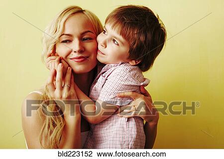Stock Image - Smiling mother hugging son. Fotosearch