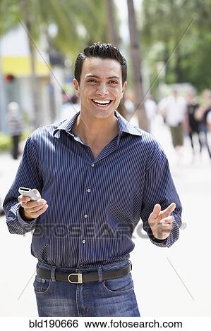 Stock Photograph - Spanish man holding cell phone. Fotosearch