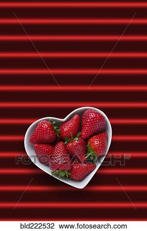 Strawberries in heart-shape bowl on red striped background View Large Photo Image Stock Image - Strawberries in heart-shape bowl on red striped background. Fotosearch