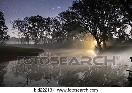 Sunrise through mist clouds in rural field View Large Photo Image Stock Photo - Sunrise through mist clouds in rural field. Fotosearch