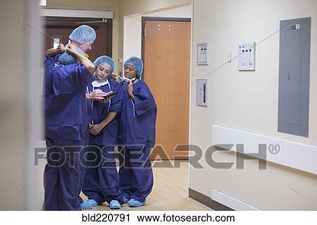 Stock Image - Surgeons talking in hospital hallway. Fotosearch