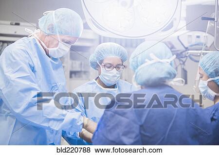 Stock Photo - Surgeons working in operating room. Fotosearch