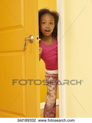 Stock Image - Surprised African girl opening door. Fotosearch