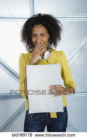 Stock Photo - Surprised Ethiopian businesswoman holding envelope. Fotosearch