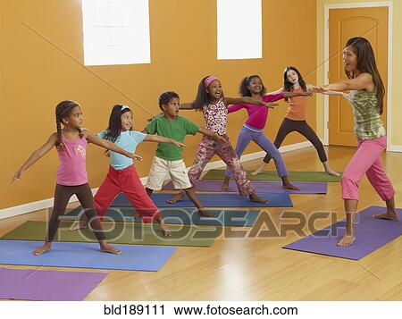 Teacher leading class of children in exercise routine View Large Photo Image Stock Image - Teacher leading class of children in exercise routine. Fotosearch