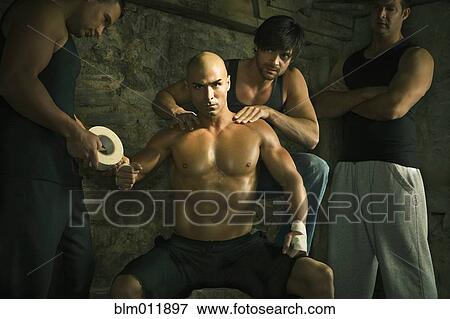 Stock Photo - Team taping boxer's hands. Fotosearch