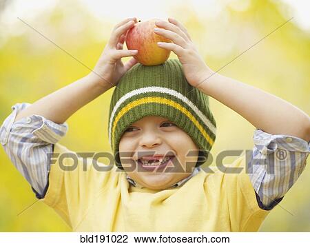 Toothless Hispanic boy balancing apple on head View Large Photo Image Stock Image - Toothless Hispanic boy balancing apple on head. Fotosearch