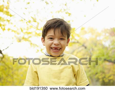 Toothless Hispanic boy grinning outdoors in autumn View Large Photo Image Stock Image - Toothless Hispanic boy grinning outdoors in autumn. Fotosearch