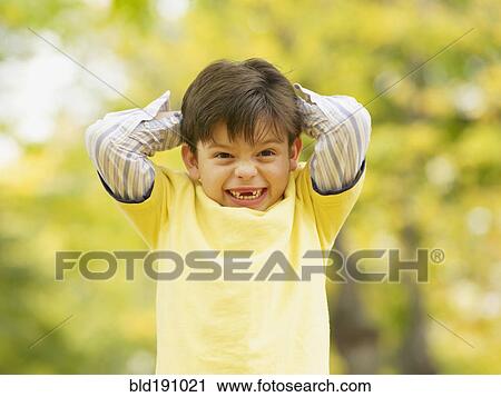 Stock Image - Toothless Hispanic boy smiling outdoors in autumn. Fotosearch