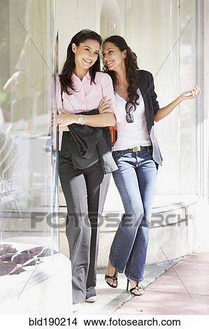 Two Hispanic woman next to store window View Large Photo Image Picture - Two Hispanic woman next to store window. Fotosearch