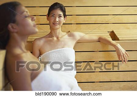 Two multi-ethnic women relaxing in sauna View Large Photo Image Stock Image - Two multi-ethnic women relaxing in sauna. Fotosearch