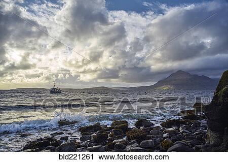 Stock Image - Waves on rocky beach. Fotosearch