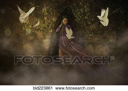 Stock Image - White doves flying around Chinese woman. Fotosearch