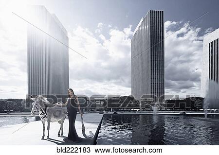 Stock Image - Woman and zebra in urban park. Fotosearch