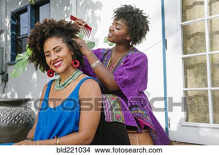 Woman combing hair of friend on porch View Large Photo Image Picture - Woman combing hair of friend on porch. Fotosearch