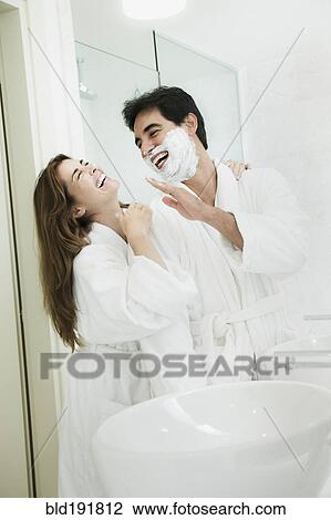 Stock Image - Woman hugging man with shaving cream on face. Fotosearch