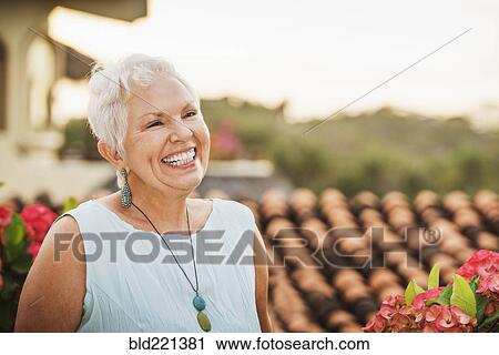 Stock Image - Woman laughing outdoors. Fotosearch