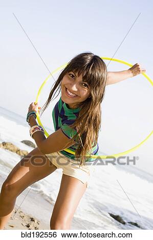 Woman playing with plastic hoop on beach View Large Photo Image Stock Photograph - Woman playing with plastic hoop on beach. Fotosearch