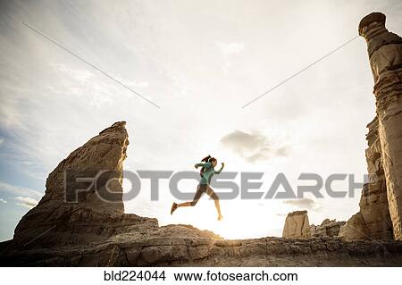 Woman running in canyon wearing backpack View Large Photo Image Picture - Woman running in canyon wearing backpack. Fotosearch