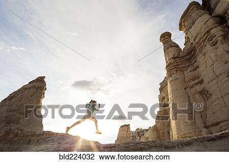Woman running in canyon wearing backpack View Large Photo Image Stock Image - Woman running in canyon wearing backpack. Fotosearch