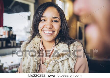 Stock Image - Woman smiling at boyfriend in cafe. Fotosearch