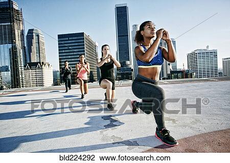 Woman stretching legs on urban rooftop View Large Photo Image Stock Image - Woman stretching legs on urban rooftop. Fotosearch