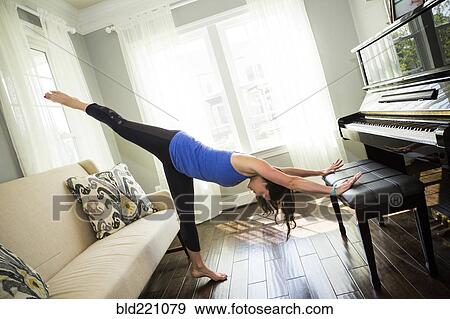 Woman stretching on piano bench View Large Photo Image Stock Photo - Woman stretching on piano bench. Fotosearch