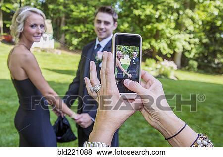 Woman taking cell phone photograph of couple View Large Photo Image Stock Photo - Woman taking cell phone photograph of couple. Fotosearch