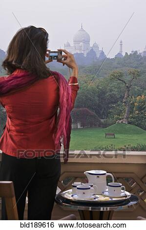 Stock Photograph - Woman taking photograph of the Taj Mahal. Fotosearch