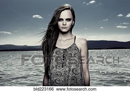 Stock Photograph - Woman wading in remote lake. Fotosearch