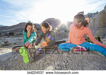 Women sitting in canyon stretching legs View Large Photo Image Stock Photo - Women sitting in canyon stretching legs. Fotosearch