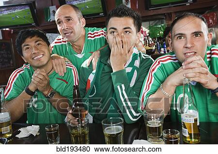 Worried men watching television in sports bar View Large Photo Image Stock Image - Worried men watching television in sports bar. Fotosearch