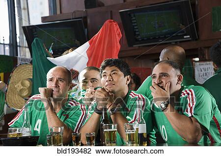 Stock Image - Worried men watching television in sports bar. Fotosearch