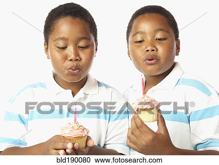 Young African twin brothers holding cupcakes with candles View Large Photo Image Stock Image - Young African twin brothers holding cupcakes with candles. Fotosearch