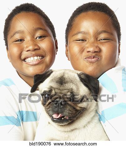 Young African twin brothers holding small dog View Large Photo Image Stock Photograph - Young African twin brothers holding small dog. Fotosearch