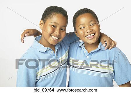 Picture - Young African twin brothers hugging and smiling. Fotosearch
