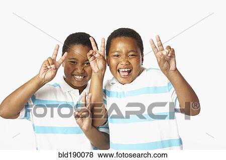 Young African twin brothers smiling and making peace sign View Large Photo Image Stock Photo - Young African twin brothers smiling and making peace sign. Fotosearch