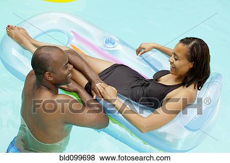 Stock Photo - African American couple enjoying swimming pool. Fotosearch