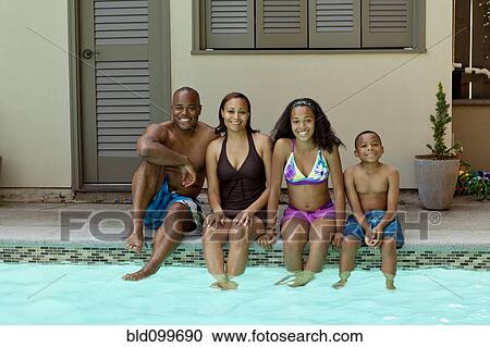 Stock Image - African American family enjoying swimming pool. Fotosearch