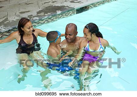 Stock Photography - African American family enjoying swimming pool. Fotosearch