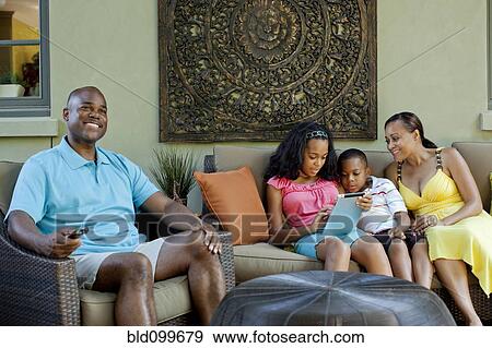 Stock Photo - African American family relaxing in living room. Fotosearch