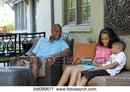 Stock Photo - African American father watching children with digital tablet. Fotosearch