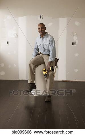 African American man holding cordless drill in unfinished room View Large Photo Image Stock Photograph - African American man holding cordless drill in unfinished room. Fotosearch