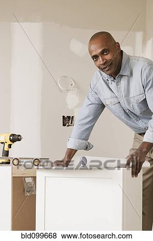 African American man looking at blueprints in unfinished room View Large Photo Image Stock Photo - African American man looking at blueprints in unfinished room. Fotosearch