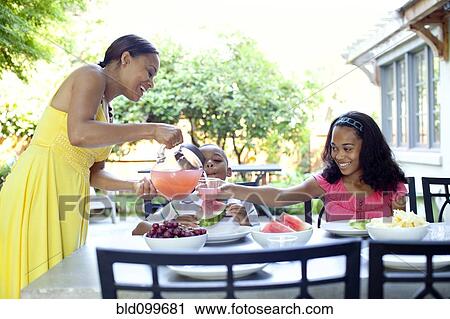 African American woman serving juice to daughter View Large Photo Image Stock Image - African American woman serving juice to daughter. Fotosearch