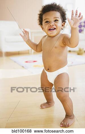 Stock Photo - Black baby girl learning to walk. Fotosearch