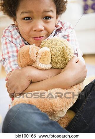 Stock Photography - Black boy hugging teddy bear. Fotosearch